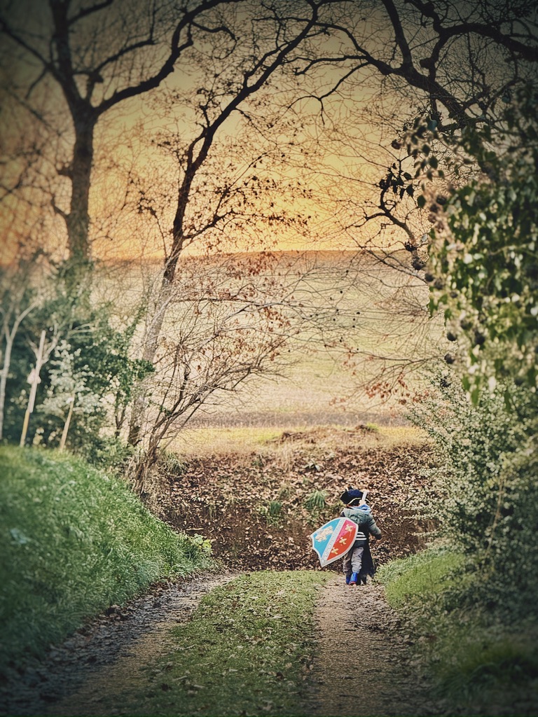 A child playing outside in the farmhouse grounds